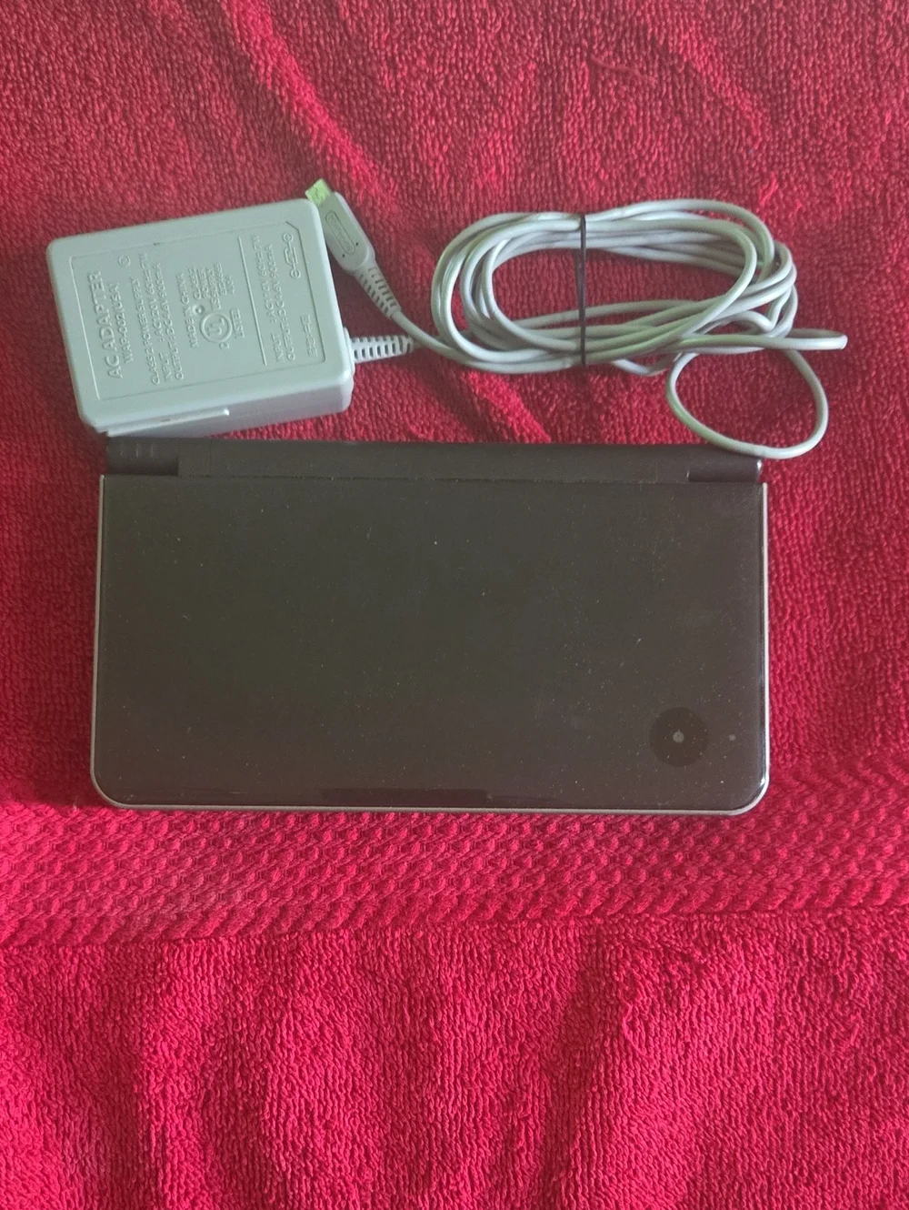 Nintendo DSi XL in black with minor scrapes and scratches